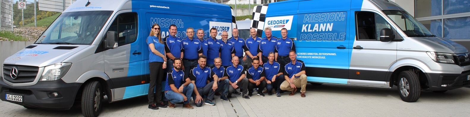 Contact persons from Gedore Automotive stand together in front of the demo vehicles.