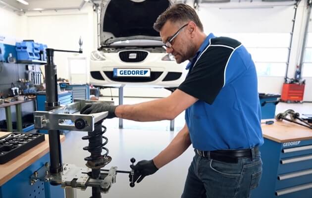 Mr. Ullrich at a spring compressor in the workshop.