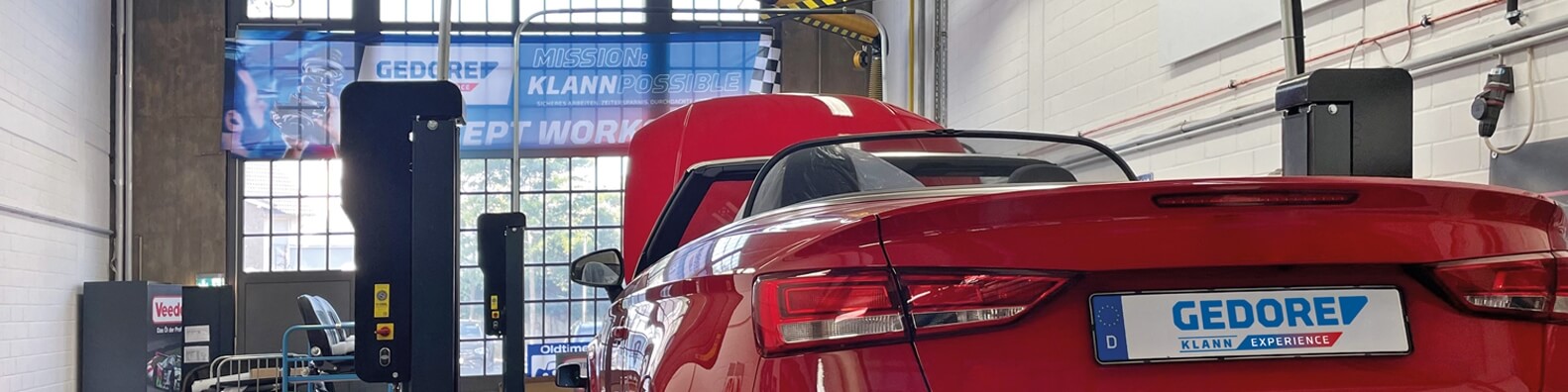 A car from behind on a lifting platform in a workshop