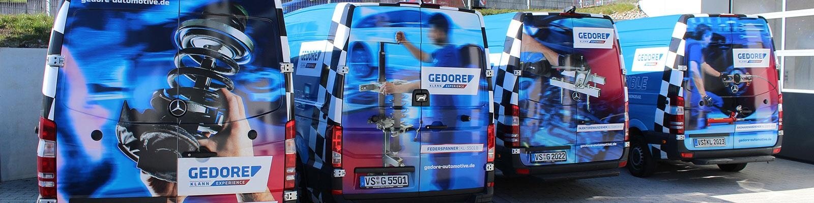 Rear view of several demo vehicles parked in front of the workshop.